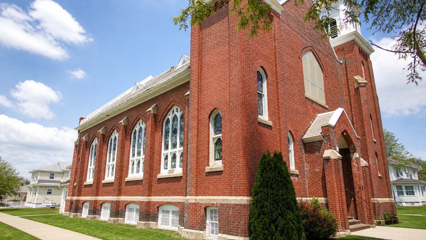 Rome God's Missionary Church, a red brick church building with stained glass windows
